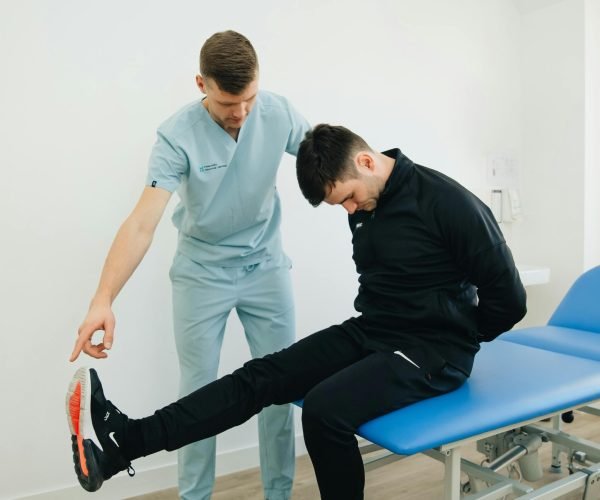 Physiotherapist instructing a patient on rehabilitation exercises in a clinic setting.